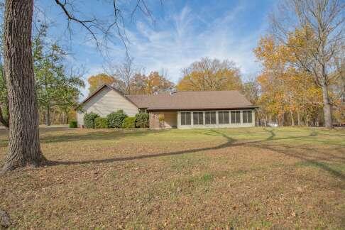 single story home featuring a sunroom and a front lawn