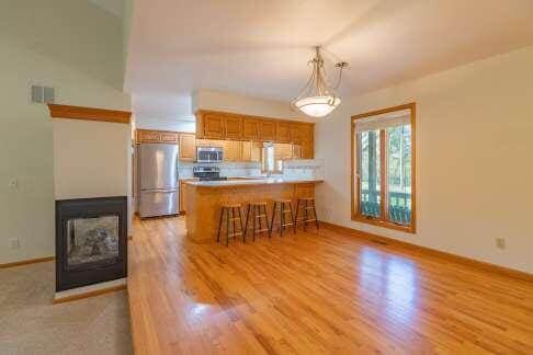 kitchen featuring a peninsula, light countertops, appliances with stainless steel finishes, a kitchen bar, and decorative light fixtures