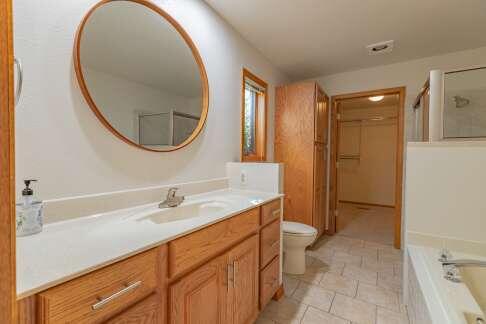 bathroom with a stall shower, toilet, a garden tub, a walk in closet, and vanity