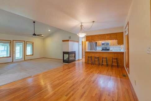 kitchen with appliances with stainless steel finishes, brown cabinets, open floor plan, light countertops, and a kitchen bar