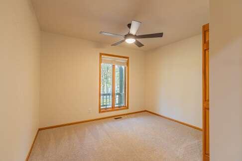 spare room with light carpet, ceiling fan, visible vents, and baseboards