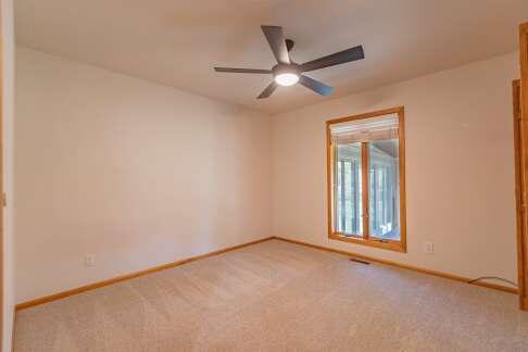 carpeted empty room featuring ceiling fan and baseboards