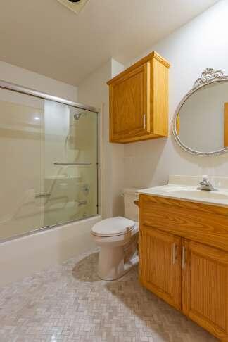 full bathroom featuring toilet, combined bath / shower with glass door, and vanity