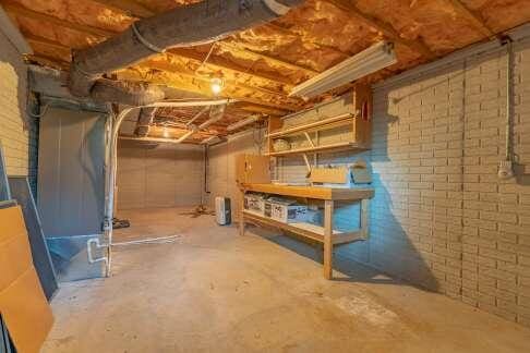 unfinished basement featuring brick wall