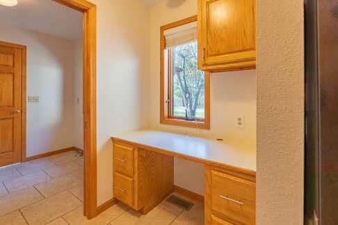 unfurnished office featuring light tile patterned floors, baseboards, and built in study area