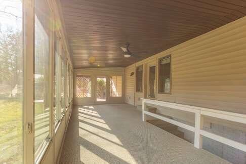 unfurnished sunroom featuring wood ceiling and a ceiling fan