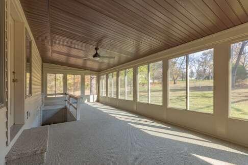 unfurnished sunroom featuring vaulted ceiling, ceiling fan, wood ceiling, and a wealth of natural light