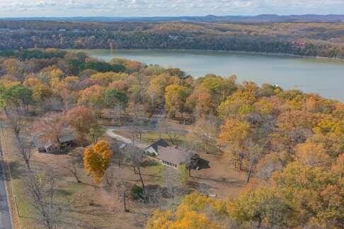 bird's eye view with a water view and a wooded view