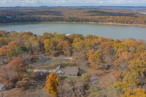 drone / aerial view featuring a water view and a view of trees