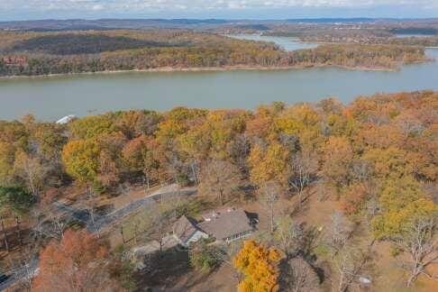 birds eye view of property with a water view and a view of trees