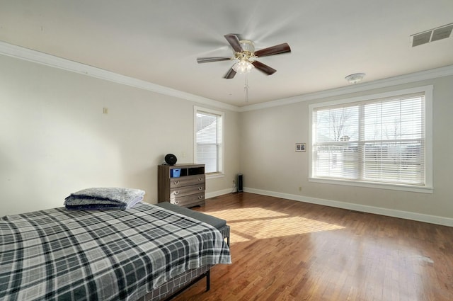 bedroom featuring ceiling fan, hardwood / wood-style floors, and ornamental molding