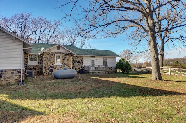 exterior space with a front yard, cooling unit, and a wooden deck