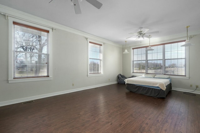 bedroom with ceiling fan, dark hardwood / wood-style flooring, ornamental molding, and multiple windows