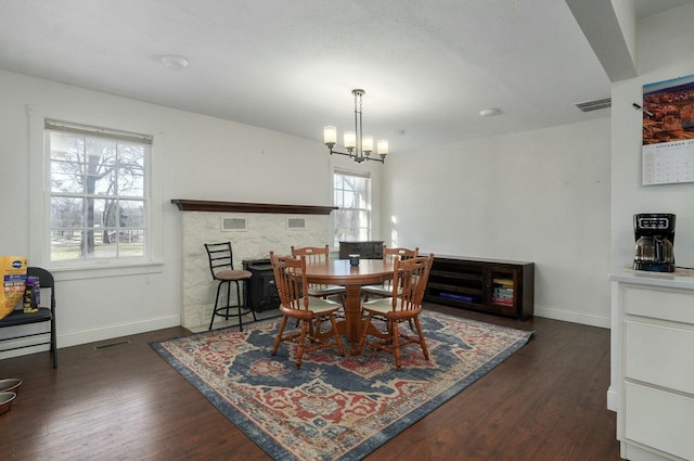 dining space featuring dark hardwood / wood-style flooring and an inviting chandelier