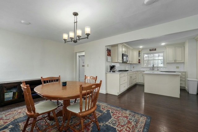 dining room featuring a chandelier, dark hardwood / wood-style floors, and sink