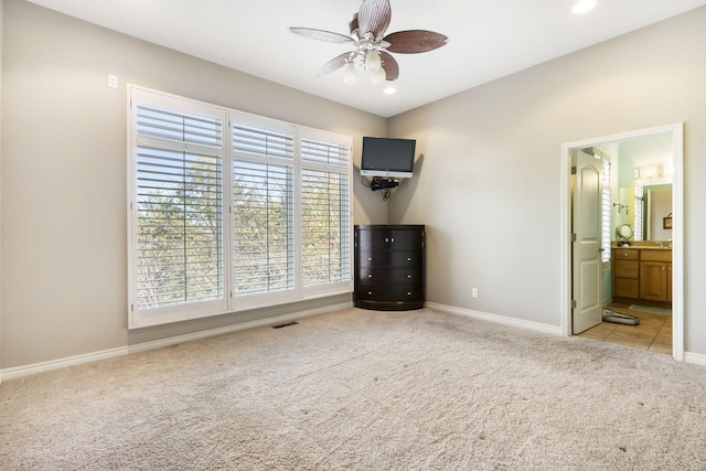 unfurnished bedroom featuring ceiling fan, connected bathroom, and light carpet