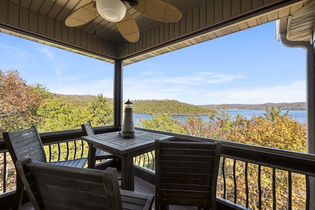 deck with ceiling fan and a water view