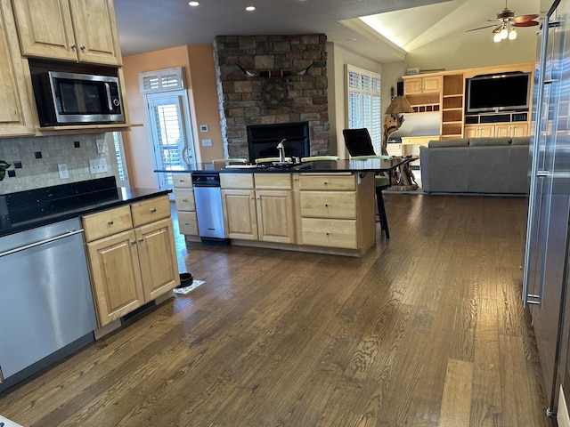 kitchen with a kitchen bar, appliances with stainless steel finishes, tasteful backsplash, dark wood-type flooring, and lofted ceiling