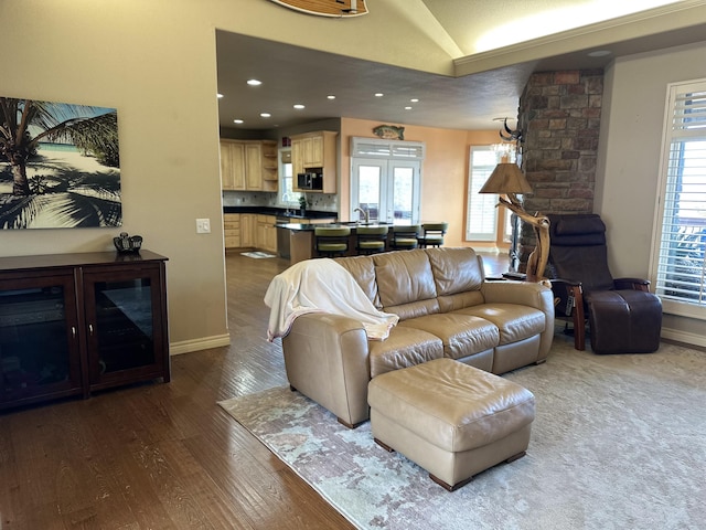 living room featuring sink, dark hardwood / wood-style flooring, and vaulted ceiling