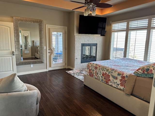 bedroom featuring access to exterior, ceiling fan, and dark hardwood / wood-style flooring