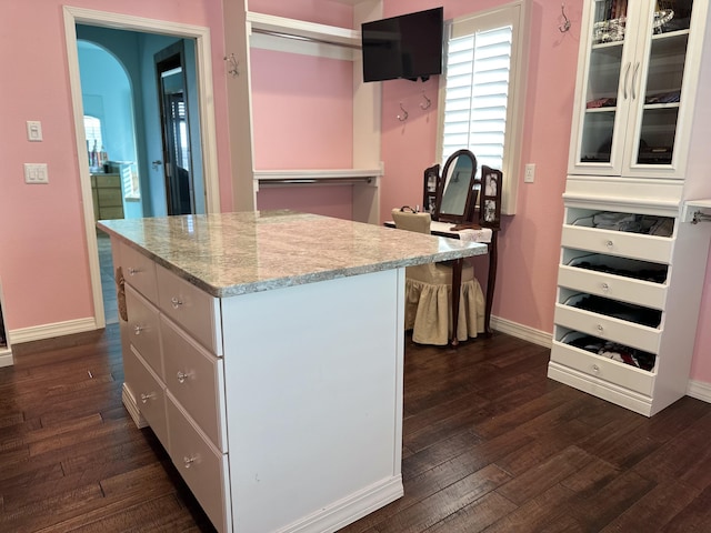 kitchen featuring white cabinets, a center island, and dark hardwood / wood-style flooring