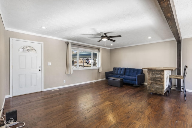 living area featuring dark hardwood / wood-style flooring, ceiling fan, ornamental molding, and a textured ceiling