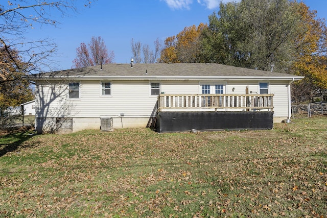 rear view of property with a deck, a lawn, and central air condition unit