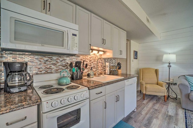 kitchen with white cabinets, white appliances, sink, and light hardwood / wood-style flooring