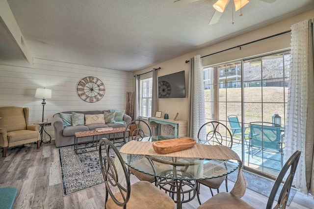 570 Abby Ln Unit 3, Branson, MO 65616 - dining room featuring ceiling fan, wood finished floors, a textured ceiling, and wood walls