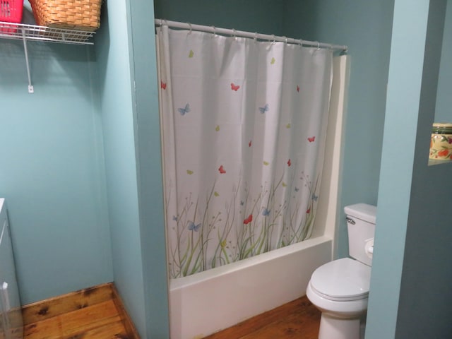 bathroom featuring toilet, hardwood / wood-style floors, and shower / bath combo with shower curtain