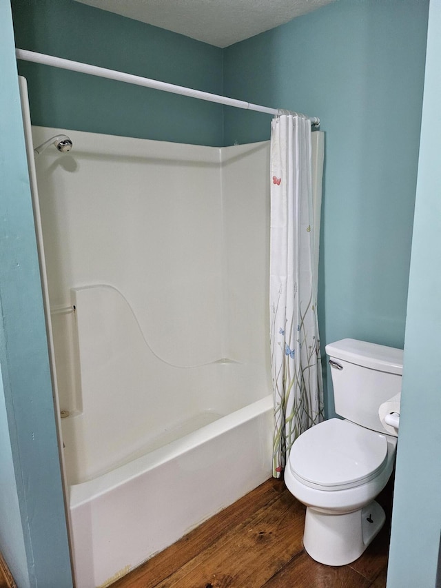 bathroom featuring shower / tub combo with curtain, toilet, and hardwood / wood-style floors