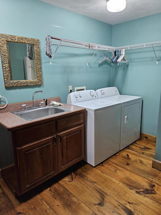 laundry area with sink, washer and clothes dryer, cabinets, and dark hardwood / wood-style floors