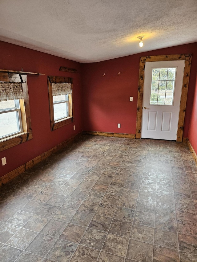 spare room with plenty of natural light and a textured ceiling