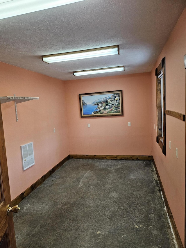 carpeted spare room with a textured ceiling