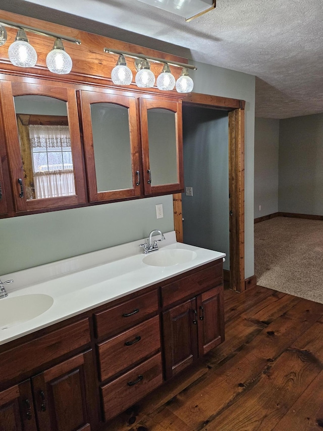 bathroom featuring vanity, wood-type flooring, and a textured ceiling