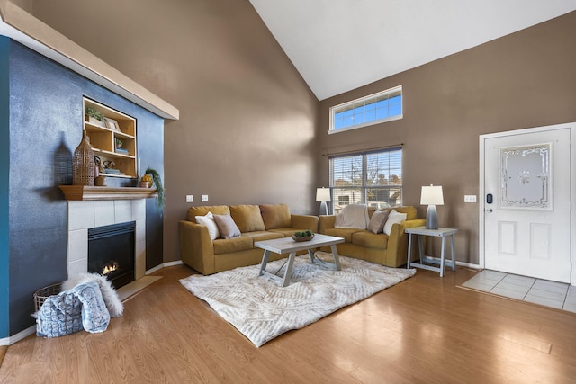 living room featuring a fireplace, hardwood / wood-style floors, and high vaulted ceiling