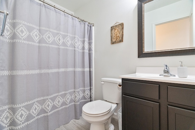 bathroom featuring vanity, toilet, and walk in shower