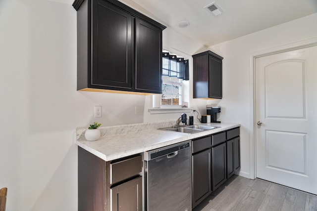 kitchen with dishwasher, sink, and light wood-type flooring