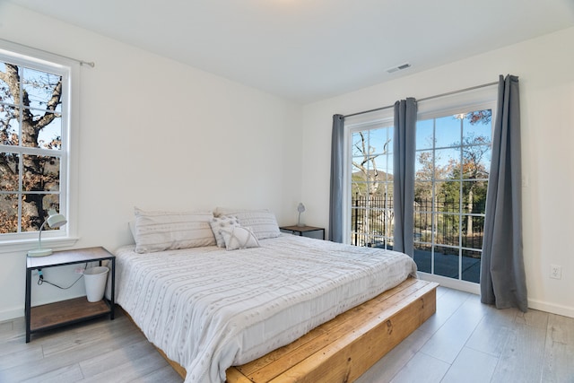 bedroom featuring access to exterior and light hardwood / wood-style flooring