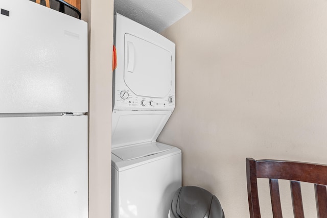 clothes washing area featuring stacked washing maching and dryer