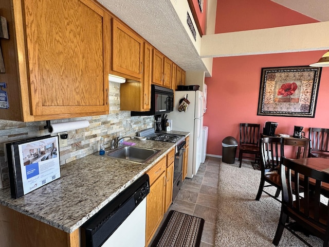 kitchen featuring backsplash, sink, stainless steel stove, and white dishwasher