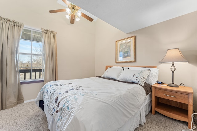 carpeted bedroom with ceiling fan and vaulted ceiling