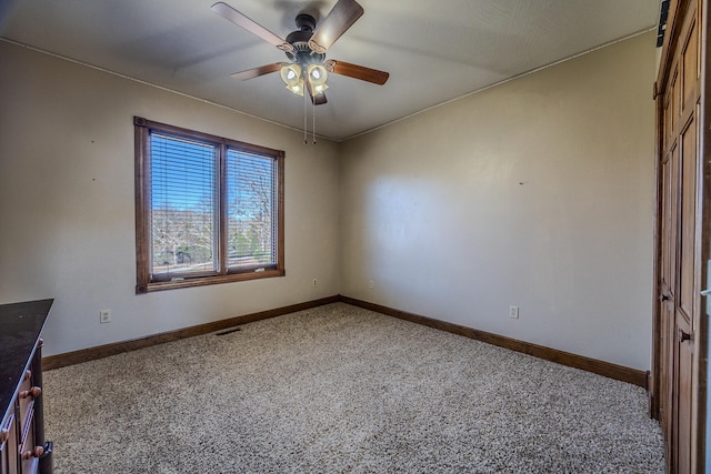 spare room with ceiling fan and carpet