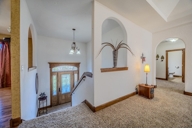 foyer with wood-type flooring and a notable chandelier