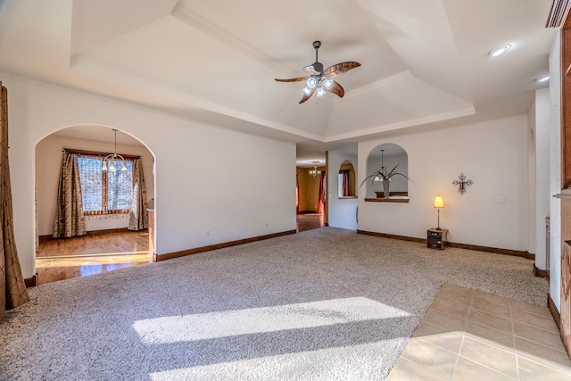 unfurnished living room featuring wood-type flooring, a raised ceiling, and ceiling fan