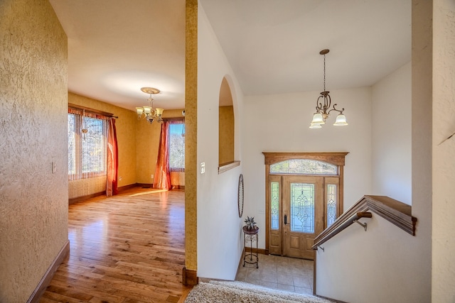 foyer entrance with a chandelier and light wood-type flooring