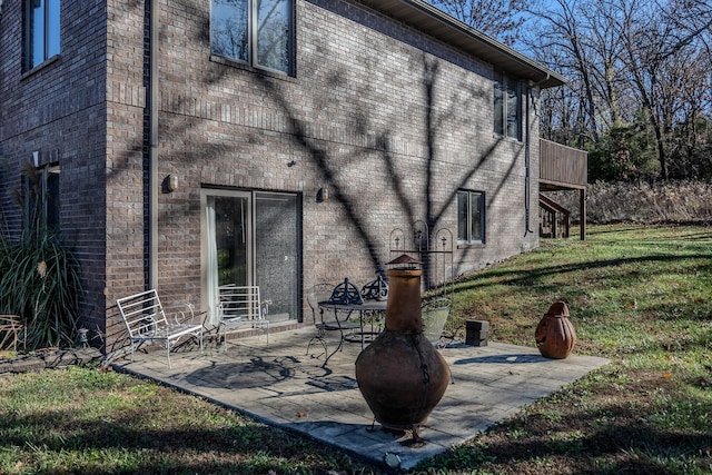 back of house featuring a lawn and a patio area