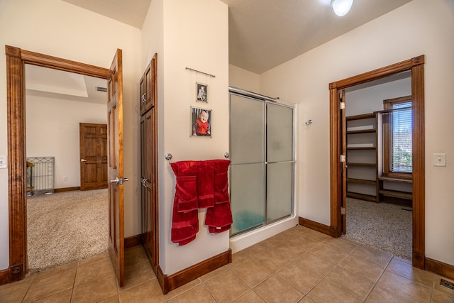 bathroom featuring tile patterned flooring and an enclosed shower