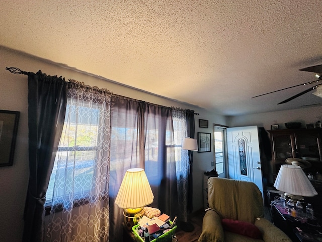 bedroom with a textured ceiling, multiple windows, and ceiling fan