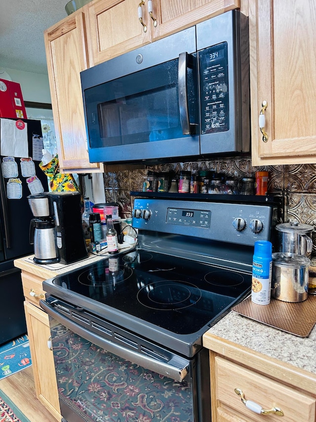 kitchen with hardwood / wood-style flooring, light brown cabinets, stainless steel appliances, and a textured ceiling